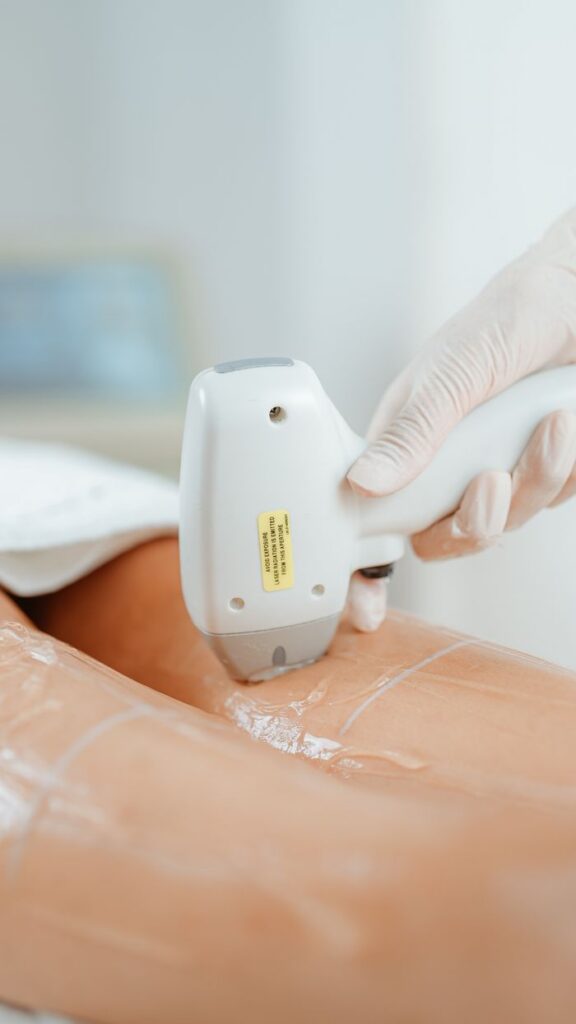 Close-up of laser hair removal procedure in beauty clinic, showcasing diode laser technology on a client's leg.